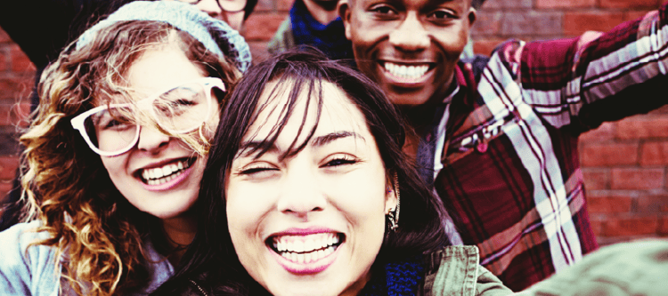 Grupo de amigos sorrindo juntos, representando felicidade, amizade e momentos divertidos. A imagem captura a alegria e a diversidade entre eles.