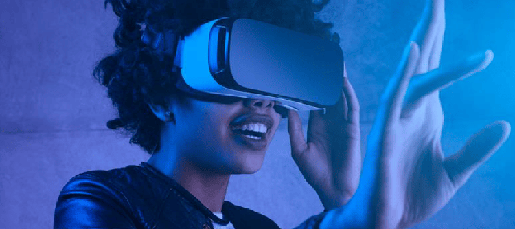 Pessoa usando óculos de realidade virtual em ambiente iluminado com luz azul, interagindo com o mundo virtual.